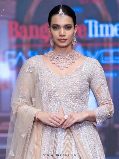 A close-up of the peach bridal Indo-Western, showcasing the dazzling aari embellishment and shimmering sequins.