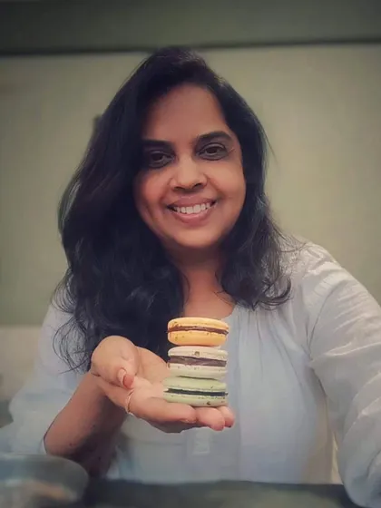 Here I am with a stack of my colorful, freshly baked eggless macarons. Baking is my passion, and I feel so much joy being able to share these sweet creations with you.