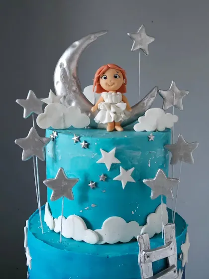 Another angle of the moon and stars cake, showing the full top tier with the figurine and the ladder leading up the side. The silver details give the cake a beautiful, celestial shimmer.