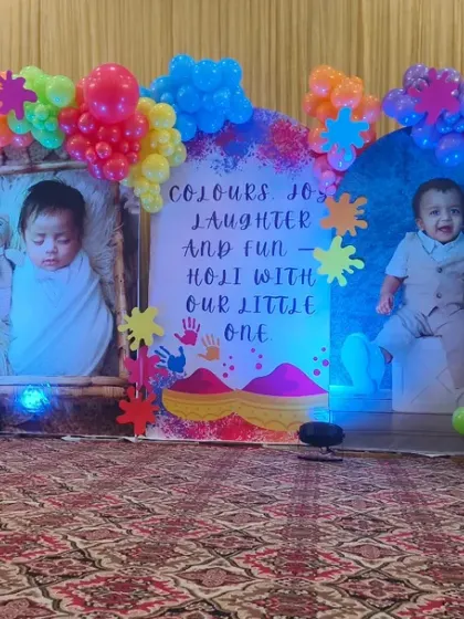 A fun Holi-themed birthday party with personalized photo panels. The backdrop is surrounded by an explosion of colorful balloons, creating a festive and playful atmosphere.