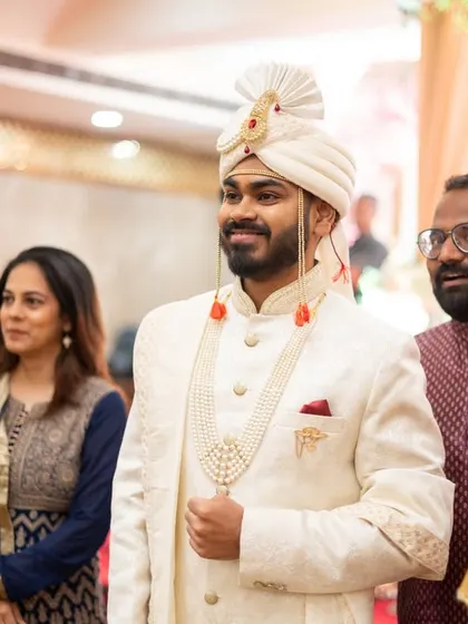 The groom waiting for his bride, with a young family member looking on.