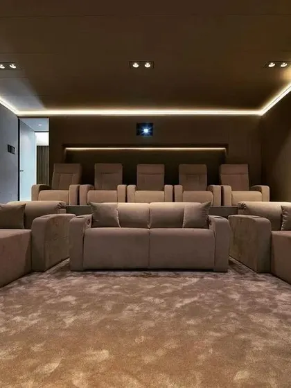 The front-on view of this plush, modern theater shows how a combination of sofas and individual seats can create a relaxed yet organized viewing environment.