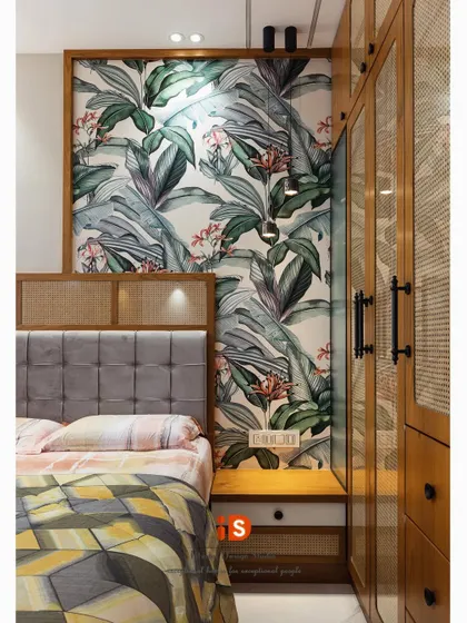 A view of the bedside area, highlighting the tropical wallpaper used as a feature wall behind the bed, creating a vibrant and stylish focal point.