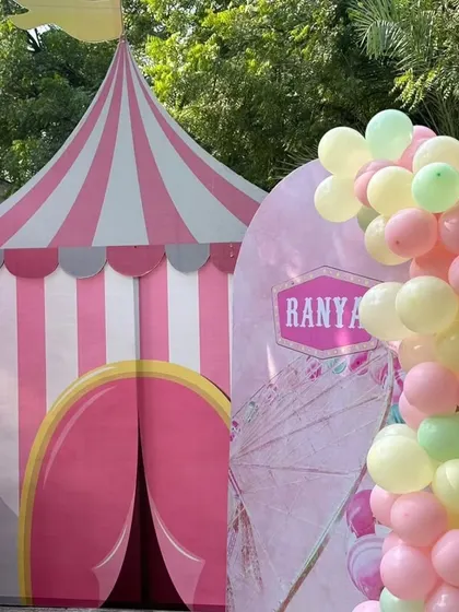 A classic circus tent prop adds to the authentic carnival atmosphere, complemented by pastel balloon arrangements.