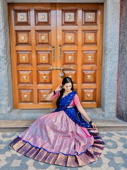 The full flare of the pink and blue silk Langa Voni skirt is displayed beautifully in this shot.