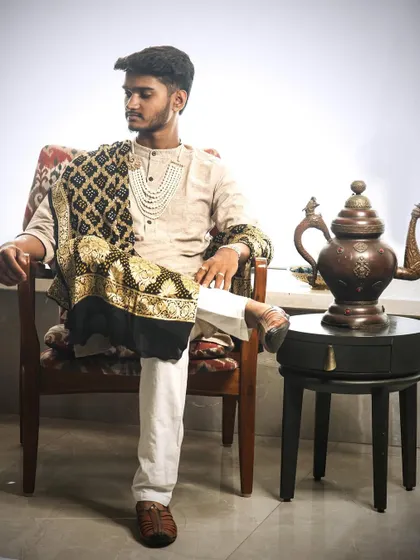 Embracing the 'Maharaja look' with a modern twist. This layered pearl necklace, fastened with a stunning Polki brooch, is a timeless accessory for any man looking to make a statement at a wedding or festive event.
