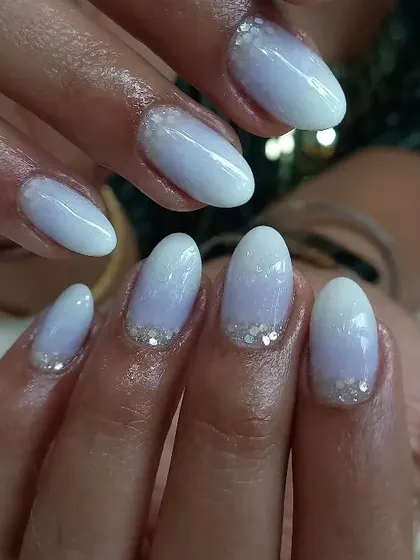 A soft, wintery look with a baby blue ombré and a delicate silver glitter accent at the cuticle.