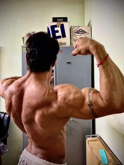 The struggle itself is enough to fill a man's soul. A powerful back and arm pose showing the beauty in the grind.
