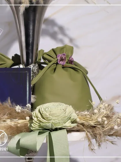 The details of The Gourmet Fest invitation, showing the custom card with the event's logo, the soft potli, and the delicate floral arrangements.