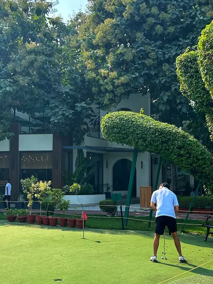 A golfer practices on the putting green in front of our unique, topiary-adorned clubhouse.