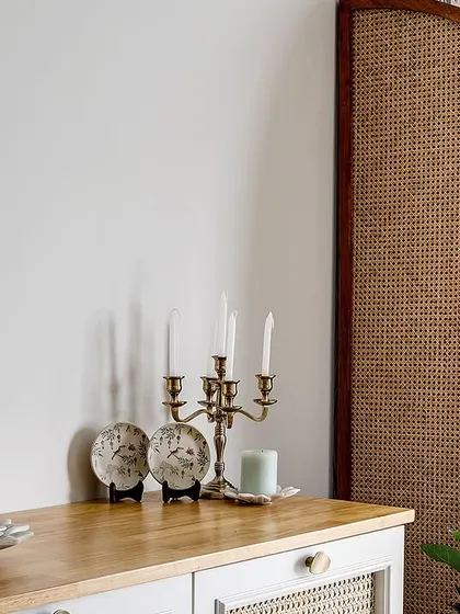 Detail of the cane partition and crockery unit, adding a layer of modern Indian charm to the dining area.