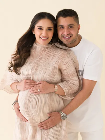 A close-up portrait of the happy couple. Their bright smiles and warm embrace radiate joy and love in this beautiful maternity photo.