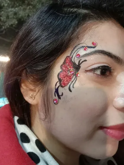 I love adding extra details like these small red gems to make a design stand out. This red glitter butterfly with black linework is a bold and dramatic choice for evening events.