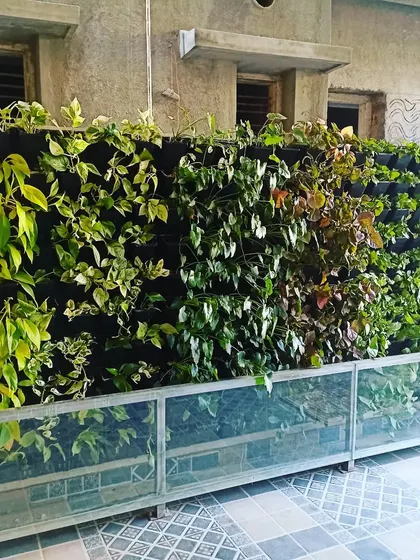 This is a vertical garden created with a felt pocket system. This method allows for dense planting, and here you can see a variety of leafy green plants creating a lush, seamless wall of foliage.