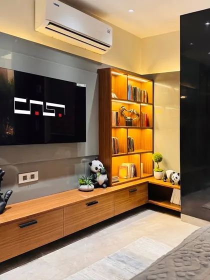 This bedroom features a custom media unit with integrated, backlit shelving, providing a warm ambient glow. A cozy window seat with storage is built in for added functionality.