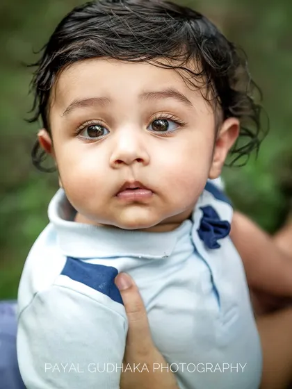 A close-up portrait of a six-month-old baby with wide, soulful eyes. This age is perfect for capturing their budding personality and curiosity.