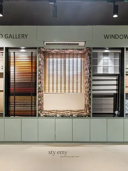 The custom-built Window Blind Gallery features illuminated niches to showcase different styles, from modern roller blinds to classic Roman shades. This allows customers to easily compare textures, patterns, and light-filtering capabilities.