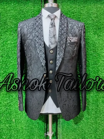 A black three-piece suit with a textured jacket and an embellished lapel.