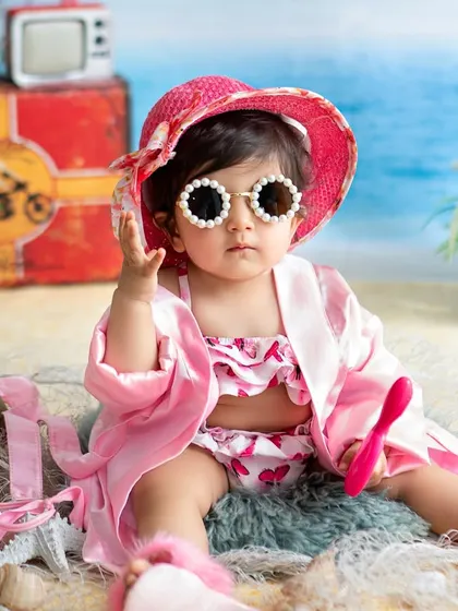 This little diva is ready for the sun in her stylish hat and pearl-rimmed sunglasses. The beach theme is perfect for capturing a fun, vacation vibe.