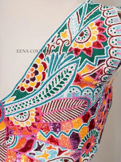 I designed this unique 'Butterfly Garden' blouse for the bride who loves color and artistry. The entire piece is covered in a vibrant mosaic of multi-colored beads and sequins, forming a stunning butterfly motif across the back.