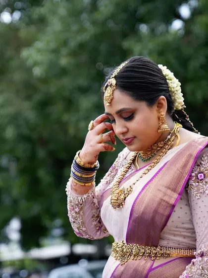 A close-up of the bride, showing her intricate jewelry and the delicate embroidery on her blouse.