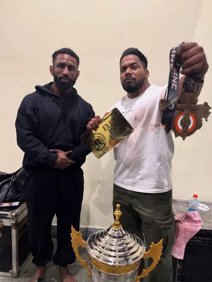 Holding the medals and trophy with my student. His victory is my victory.