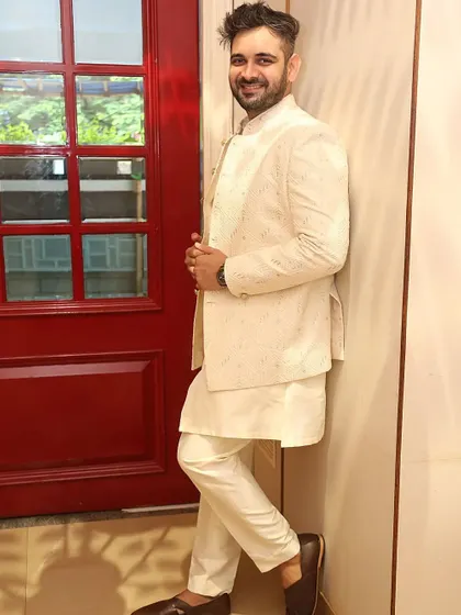 This cream-colored Jodhpuri is made from a computerized fabric with a subtle texture. It's paired with a matching kurta and trouser for a clean, monochromatic look.