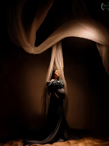 An ethereal portrait using flowing fabric and dramatic lighting to create a sense of movement and grace.