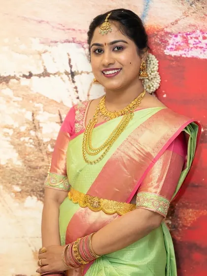 This bride's smile says it all. Her makeup is kept fresh and luminous to let her natural beauty shine, paired with a gorgeous silk saree and traditional gold jewellery.