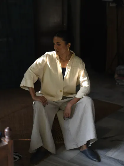 A quiet, contemplative shot for House of Wandering Silk. The play of light and shadow highlights the simple elegance of the outfit.