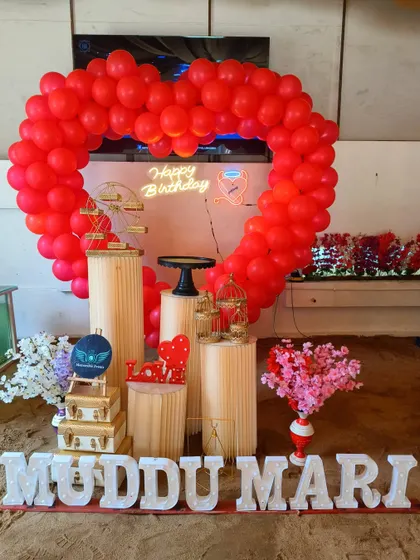 A romantic heart-shaped balloon arch with 'MUDDU MARI' in marquee letters, showing our ability to create personalized messages.
