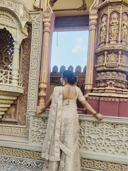 This image shows the back of the hairstyle and the elegant draping of the lehenga. I believe the entire look, from makeup to hair and styling, should come together seamlessly.