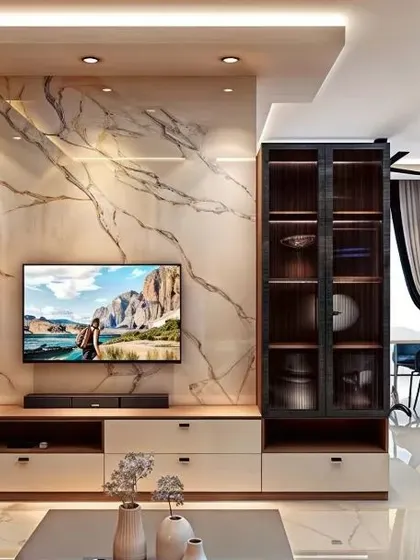 A sophisticated living room at SBR Pravanika featuring a marble-finish TV wall panel, custom shelving, and elegant lighting that creates a luxurious ambiance.