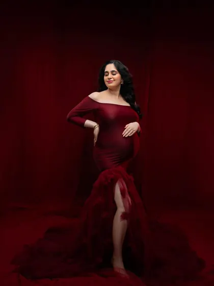 A serene pose in the red gown, capturing the peaceful anticipation of motherhood. The way the light falls on the fabric highlights the texture and rich color.