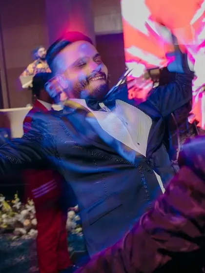 A high-energy motion blur shot of the groom dancing with his friends, capturing the wild and fun spirit of the sangeet night.