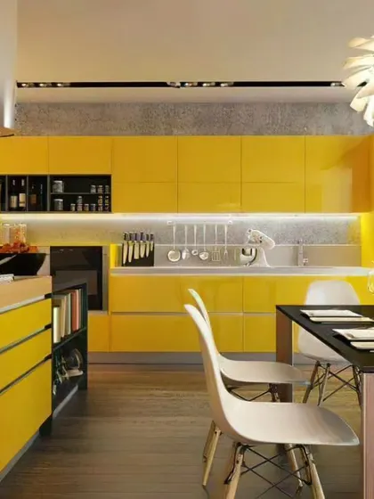 This kitchen makes a bold statement with vibrant, glossy yellow cabinets. The design includes an island with a wood countertop and an integrated dining table, making it a social hub.