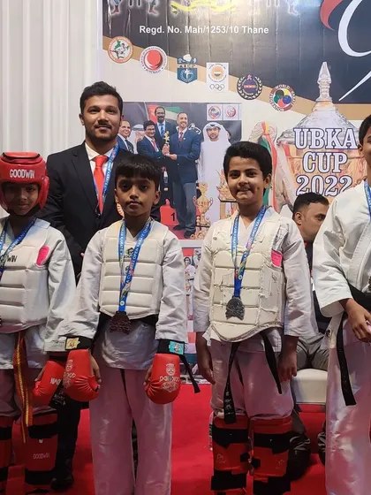 Our young kumite fighters after their matches at the UBKA Cup 2022. Dressed in full protective gear, they stand with their instructor, having gained valuable sparring experience in a safe, competitive setting.