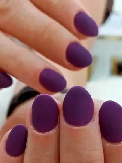 A chic and modern matte purple manicure on short, rounded nails. The matte top coat gives a velvety, sophisticated finish.