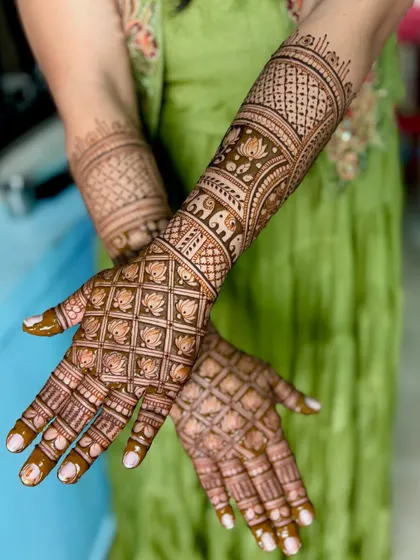 A view of the back of the hands, featuring intricate jaali work with lotus patterns, ensuring the design is beautiful from all angles.