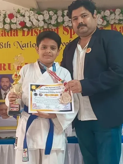 Another one of our blue belt champions from the Karwar open national level tournament, proudly displaying his medal, trophy, and certificate.