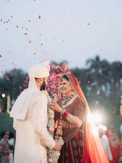 A shower of rose petals during the varmala exchange. This classic tradition never fails to create a beautiful, cinematic shot.