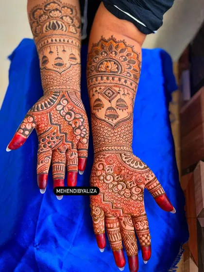 Another angle of this stunning bridal design, showing how the patterns wrap around the hands and arms. The contrast against the blue background makes the art pop.