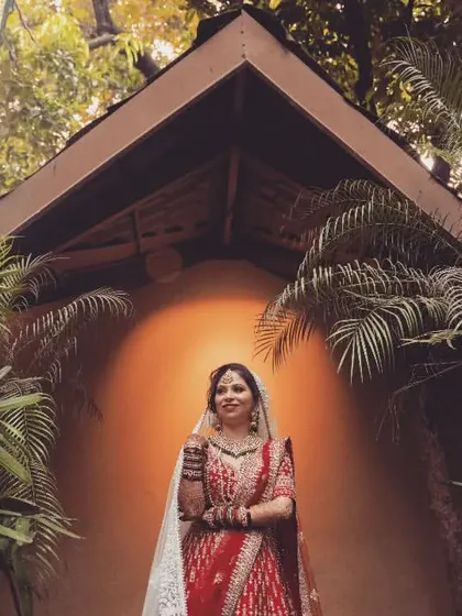 An environmental portrait of a bride, framed by the architecture and lush greenery of her wedding venue.