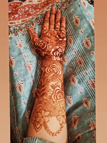 A photo showcasing the deep, even stain of a floral bridal design. The rich color against the skin is the hallmark of high-quality, natural henna.