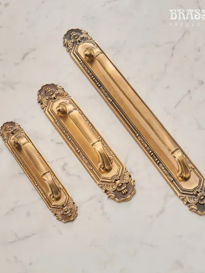 These main door handles from the Mumtaz Collection feature a substantial backplate with ornate, classical detailing. They are designed to create a grand and impressive entrance.