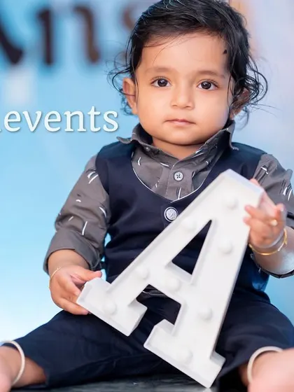 A professional shot of the birthday boy with his initial, matching the Boss Baby theme.