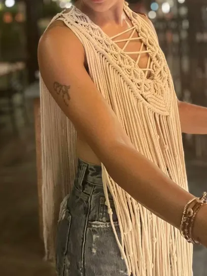 A side view of the macrame cape, showing how it drapes beautifully. You can wear it over a simple top or on its own. It’s a lightweight and airy piece, handmade with soft cotton.