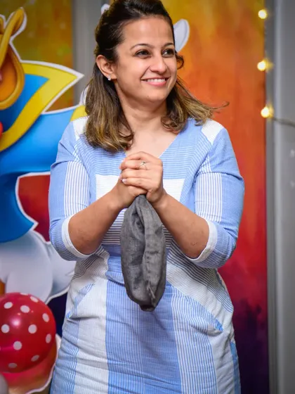 A parent volunteer looks on with a smile, ready to participate in a magic trick. It's fun for the whole family.