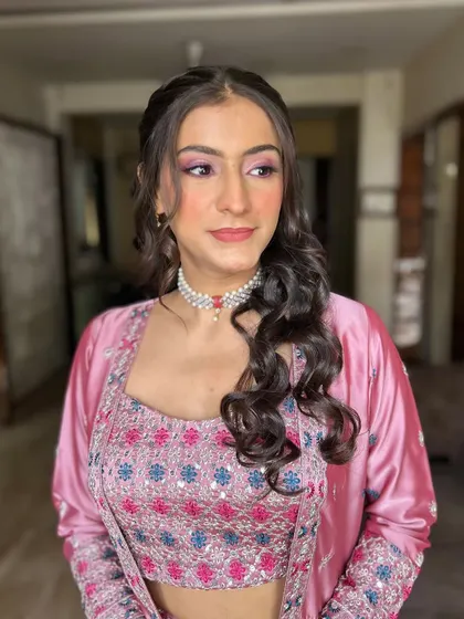 This side profile shows how the makeup and hair work together. The soft curls frame her face beautifully, highlighting the glowing makeup.