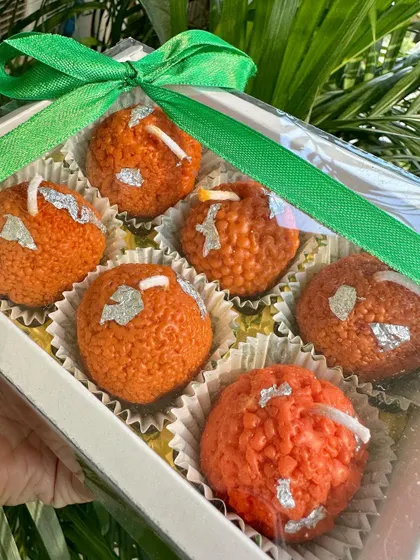 A single boondi laddoo candle held in hand, showcasing its realistic texture and detail. This is a perfect, quirky gift to light up someone's day during the festive season.